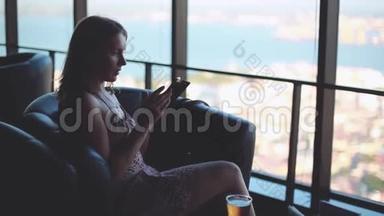 女商人用她的手机在<strong>商务</strong>中心发送信息，从窗口可以看到城市景色。 1920x1080